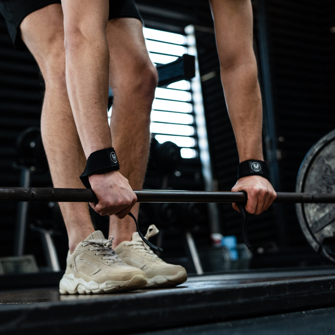 Zwarte lifting straps voor weightlifting in gebruik tijdens een oefening